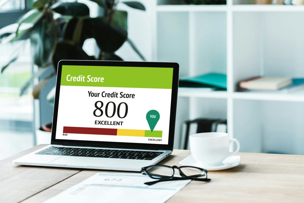 cup of coffee near laptop with credit score lettering and numbers on screen